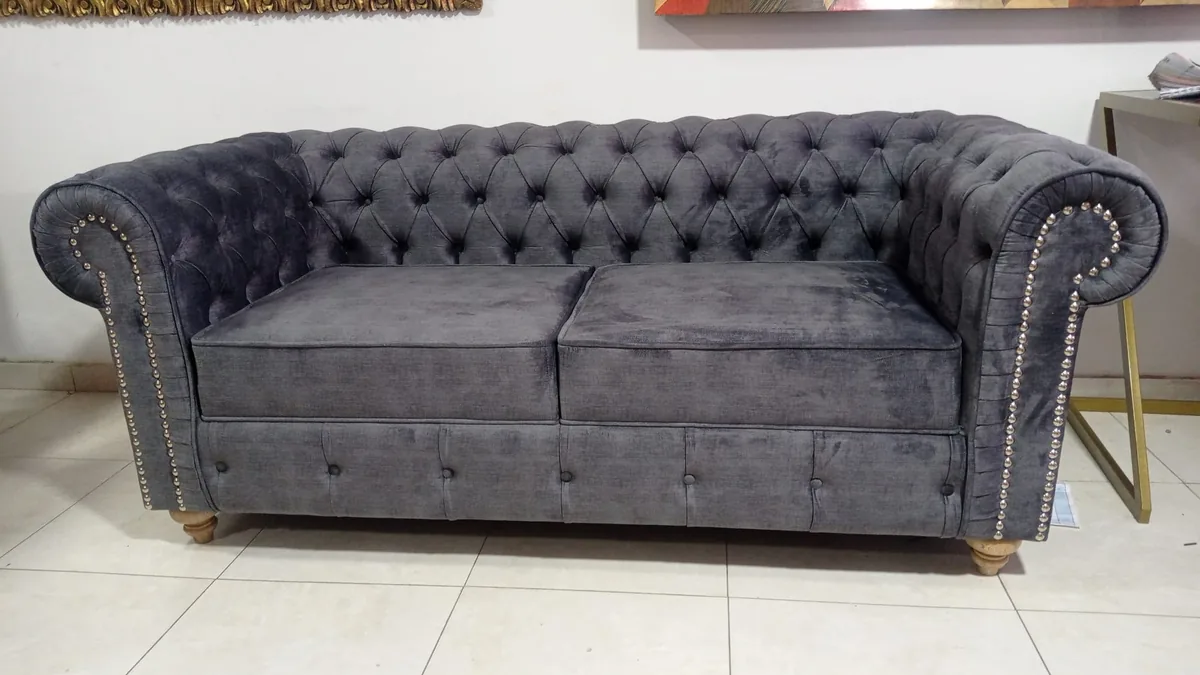 Sofá Chesterfield tapizado en velvet gris de dos plazas