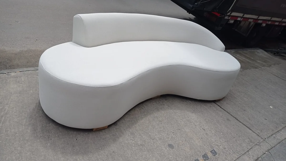 Sofá curvo tapizado en blanco fabricado a medida