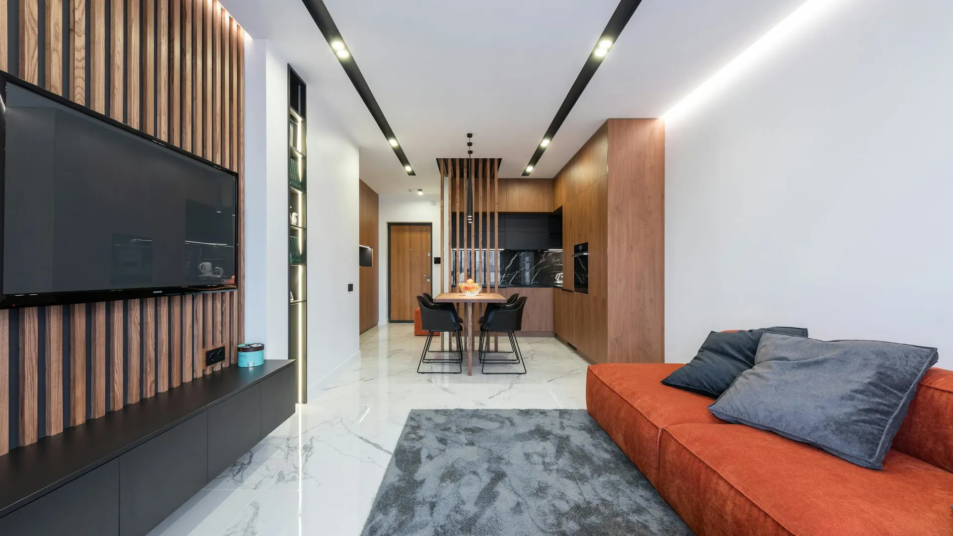 Salón abierto con sofá tapizado y cocina integrada en apartamento contemporáneo de Alcorcón